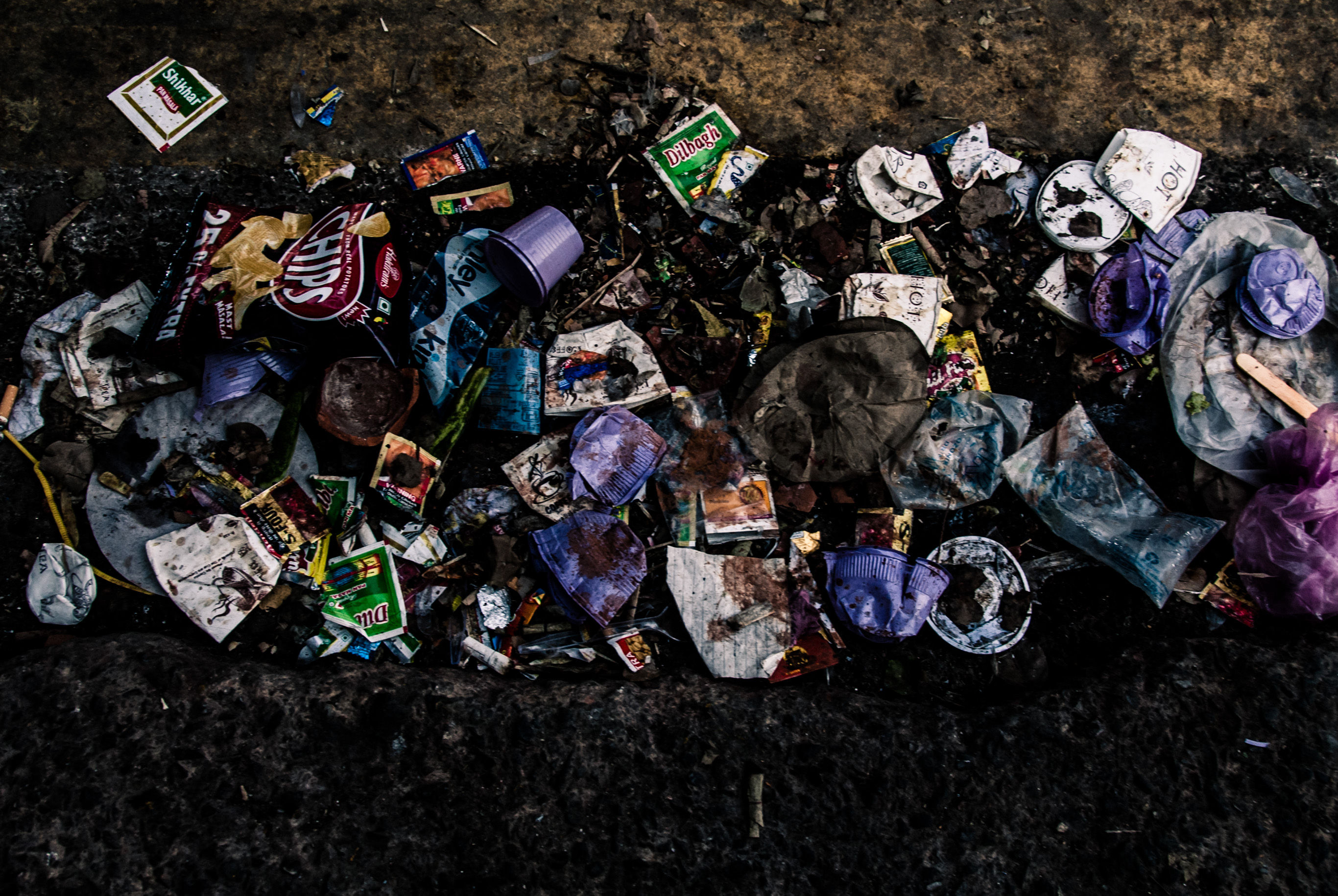 Des déchets plastiques éparpillés sur un sol sombre