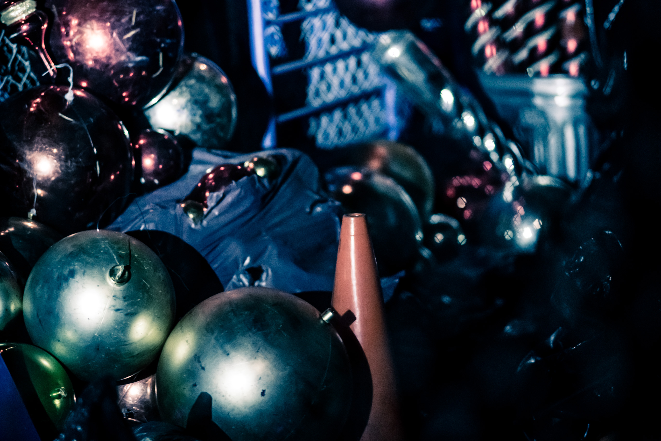Des boules métalliques et des décorations de Noël dans une vitrine, de nuit