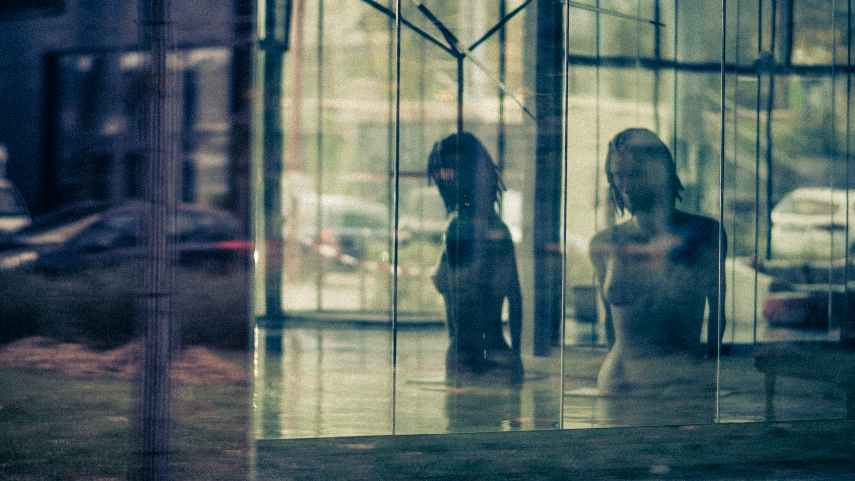 Deux silhouettes de mannequins reflétées dans une vitrine