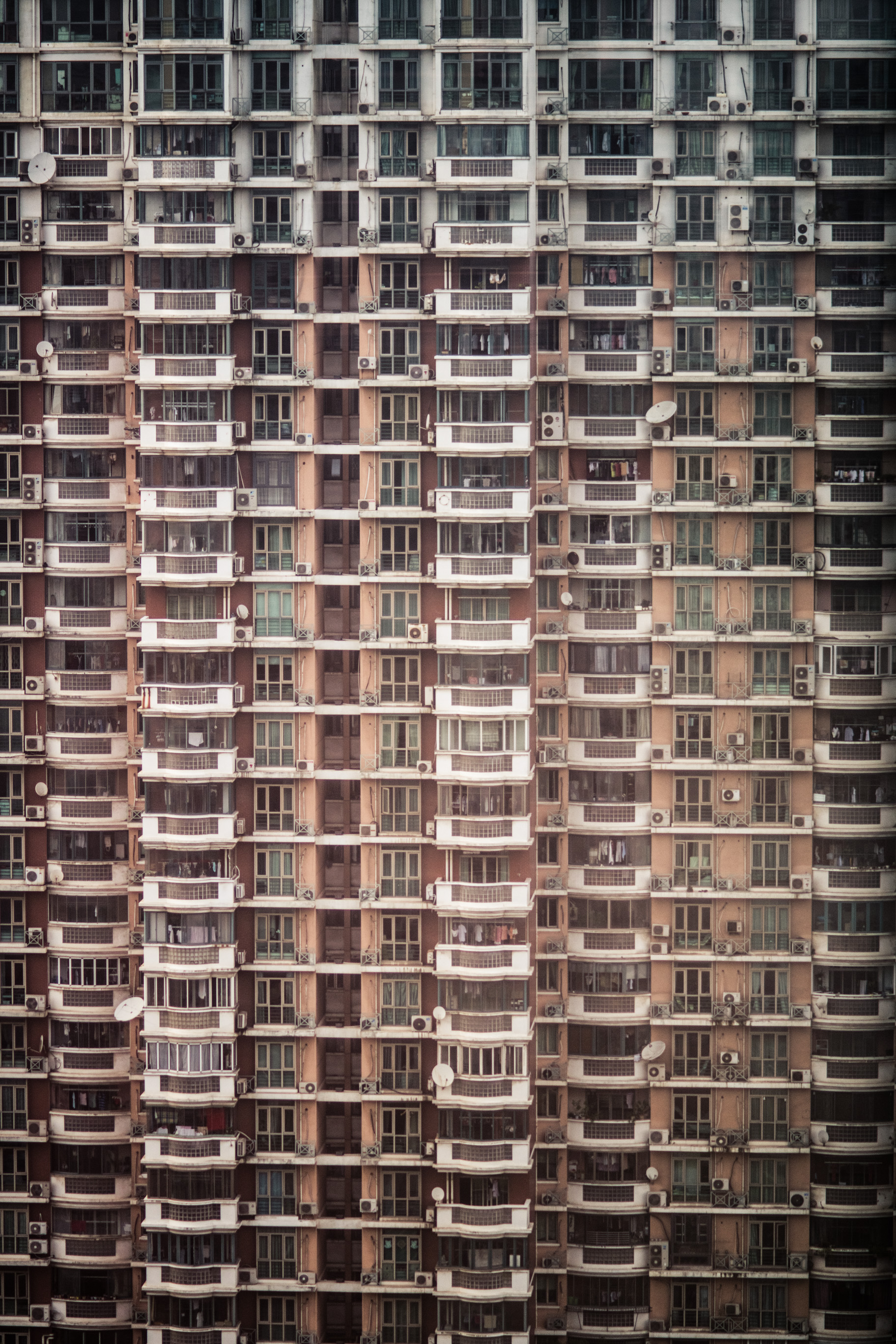 Une façade d'immeuble d'habitation de grande hauteur, des centaines de fenêtres et de balcons